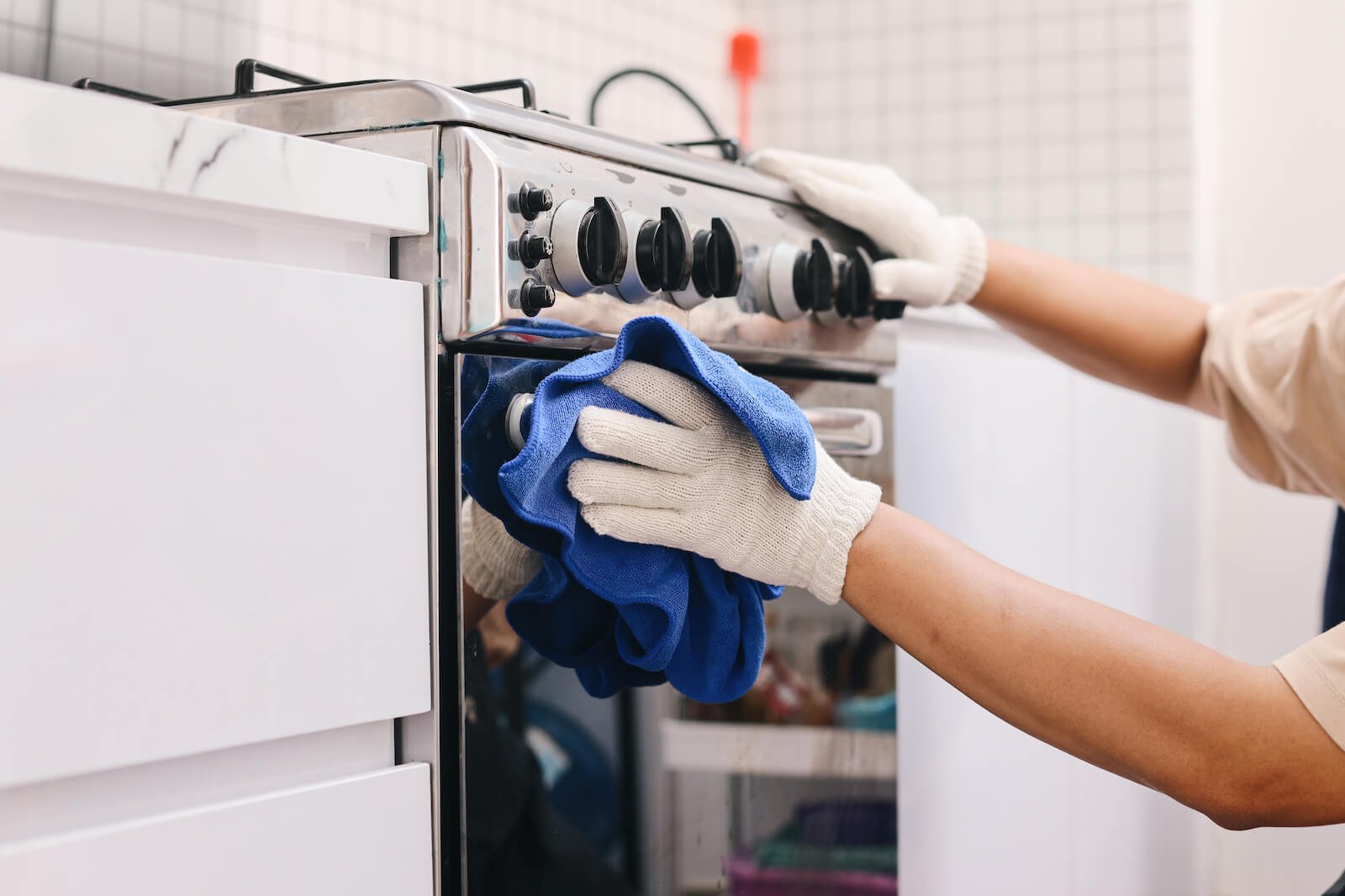 Hands with latex gloves cleaning oven