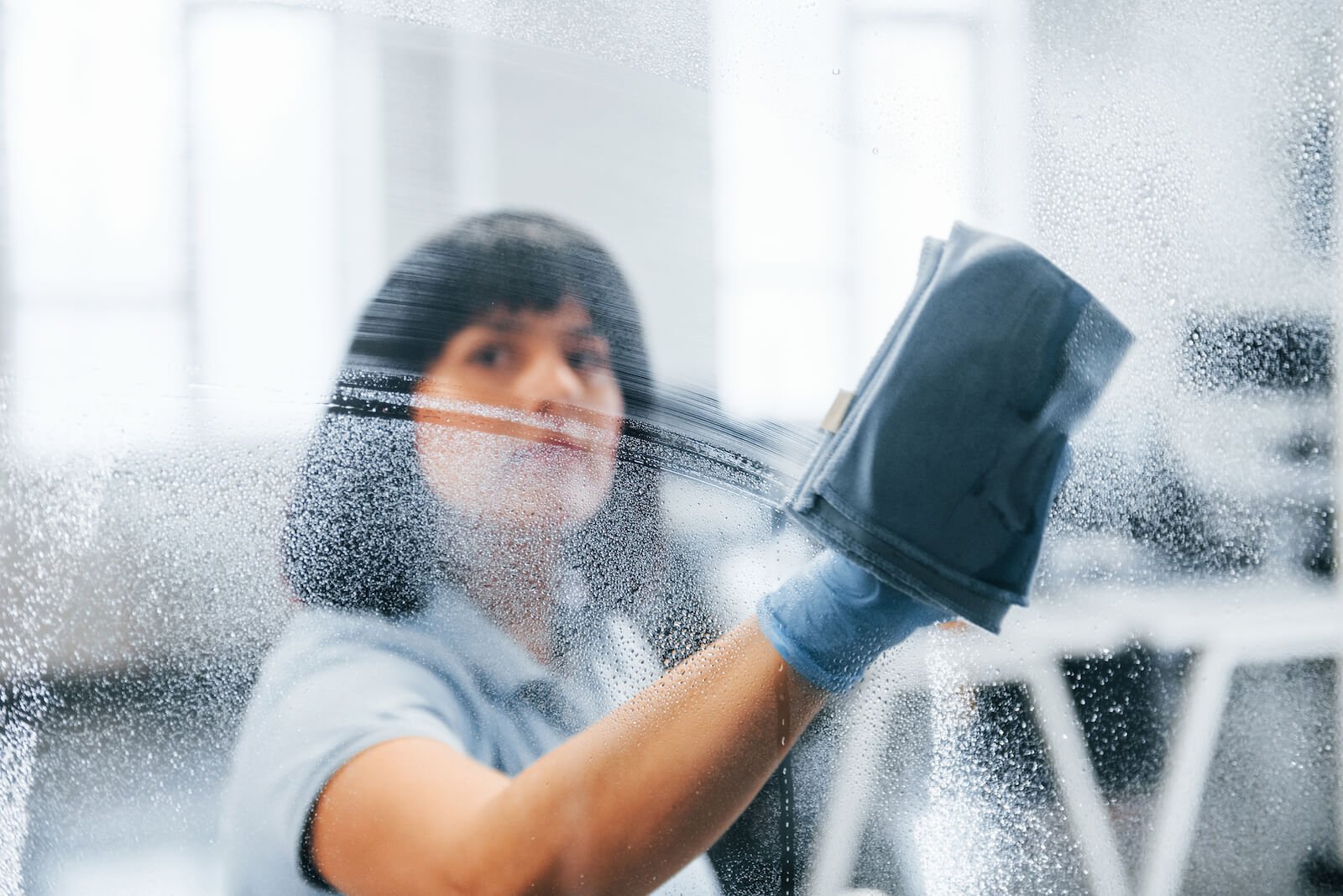 woman cleaning windows at commercial office